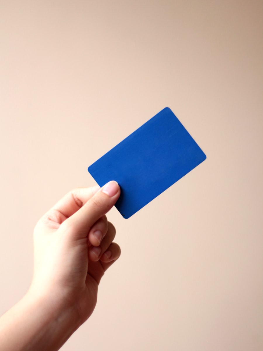 A hand holding up a blank blue card